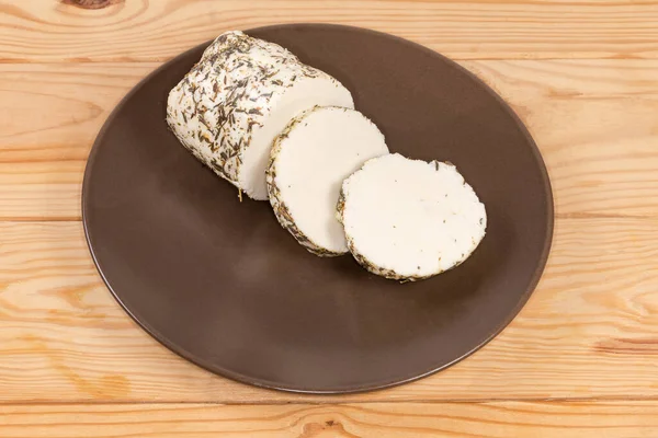 用各种牛奶混合制成的软软奶酪片 用不同的香料和香草揉碎 放在褐色的盘子里 放在烧烤炉的桌子上 — 图库照片
