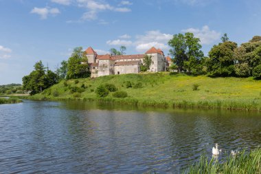 Önünde göl olan antik şatonun genel manzarası. 15. yüzyılın Svirzh Kalesi, Ukrayna