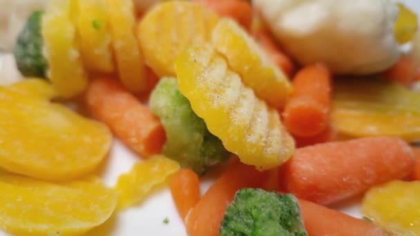 皿の上で異なるスライスされた冷凍野菜クローズアップ — ストック動画