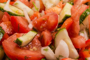 Taze domatesle yapılan sebze salatası, kırmızı dolma biber, salatalık ve soğan, yakın plan üst görüntü.