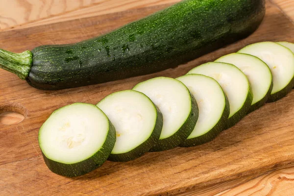 One Dark Green Zucchini Sliced Circles Same Whole Zucchini Wooden — Stock Photo, Image