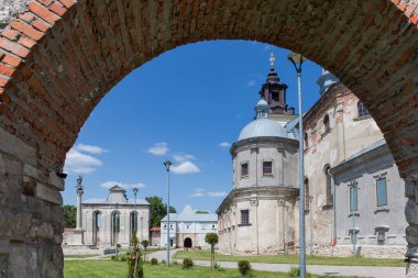 15. yüzyılda Pidkamin köyündeki eski güçlendirilmiş Dominik Manastırı kompleksi, ilkbaharda güneşli bir günde avludaki kemerden manzarası, Ukrayna