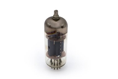 Yüksek voltajlar için üst kapak bağlantıları olan eski bir elektronik vakum tüpü beyaz arka planda duruyor.