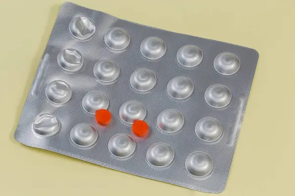 Dos Píldoras Rojas Medicación Encuentran Blister Aluminio Sobre Una Superficie —  Fotos de Stock