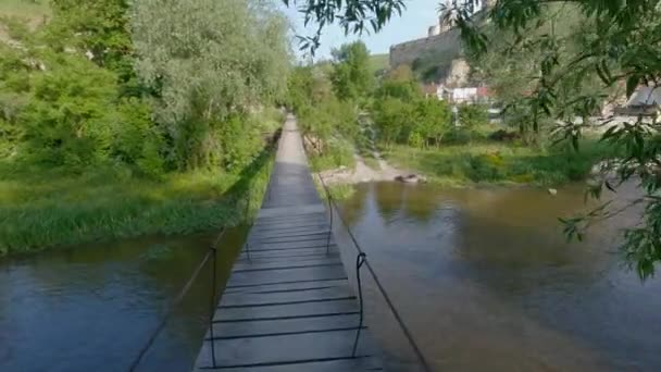 Fußgänger Hängebrücke Mit Holzdeck Über Den Fluss — Stockvideo