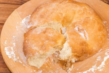 Un serpiştirilmiş tahtanın üzerine parçalanmış, kalın, gür lavaş parçaları serpiştirilmiş.