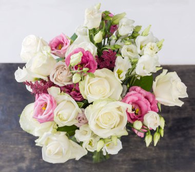 Beyaz ve pembe güllerin buketi ve siyah arka planda siyah bir vazoda beyaz Eustoma, seçici odak üst görünümü