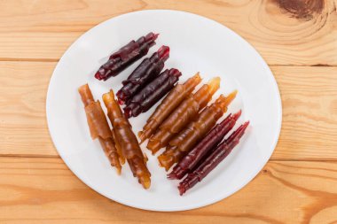 Elma püresi ile yapılan doğal ince yumuşak esnek pastila düşük sıcaklıkta kuruyor ve kırsal masada beyaz tabakta tüplere sarılıyor.