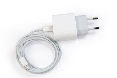 AC Europlug ve Lightning kablolu beyaz şarj cihazı taşınabilir elektronik aksesuarların şarj edilmesi için çıkış soketine bağlı, beyaz arka planda üst görünüm