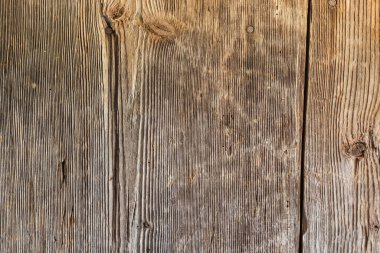 Eski ahşap tahtaların yüzeyi düğümlerle kaplı, dikey konum ve karanlık bir ortaçağ binası.