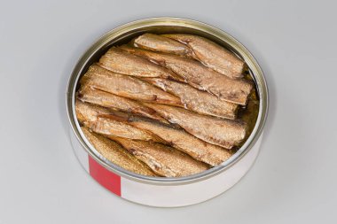 Açık teneke kutunun içinde tütsülenmiş lahanalar gri arka planda kapanıyor.