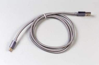 Gri arkaplan kenarlarında USB Tip-A ve Tip-C ile örülmüş kablo
