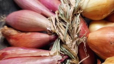 Shallot ve sıradan soğanlar siyah yüzey üzerinde örülmüş.