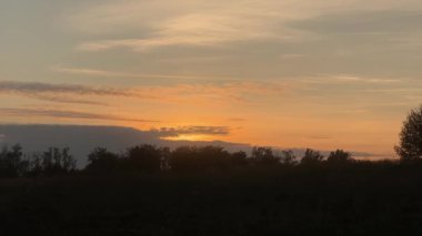 Günbatımında gökyüzüne karşı toprak yetiştiren traktörlü tarım arazisi