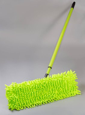 Yeşil düz ıslak paspas, yeniden kullanılabilir yıkanabilir ksenille mikrofiber bez pedi ve gri arka planda plastik teleskopik sapı var.