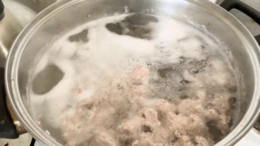 Tencerede pişirilirken et suyu ve köpük.