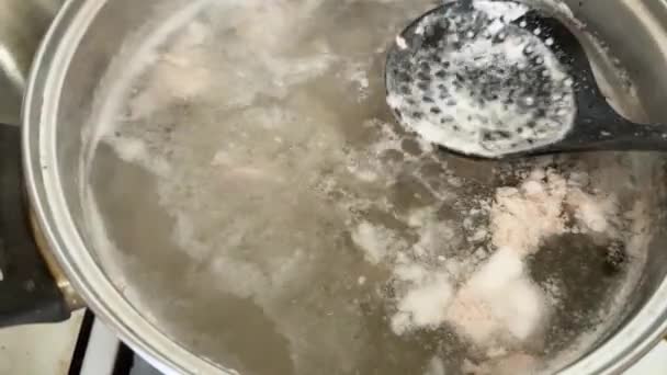 烹调过程中的肉汤和在锅里用撇子撇去肉 — 图库视频影像