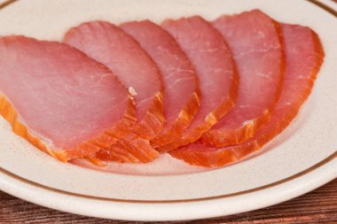 Kurumuş domuz filetosunun ince dilimleri bir fincan tabağında, yan görüntüsü seçici odak noktasında.