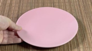 Boş pembe tabağı ve kaseyi bambu masa paspasına koyuyorum.