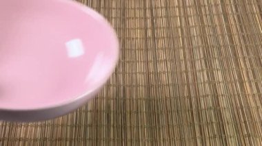Bambu masa paspasına boş pembe bir tabak koyuyorum.