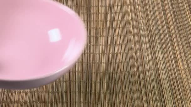 Положить Пустую Розовую Глубокую Тарелку Коврик Бамбука — стоковое видео