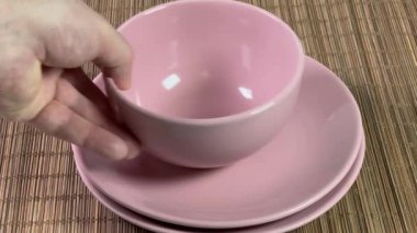 Pembe bir tabağı kaldırıyorum ve yukarıdan kase koyuyorum.