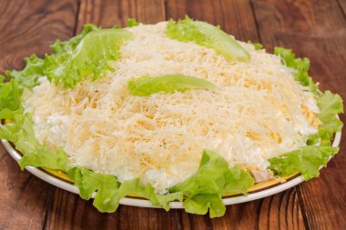 Haşlanmış tavuk eti salatası, konserve ananas ve mısır, marul, rendelenmiş yumurta ve peynir kırsal bir masada, seçici odak noktasında yan görünüm