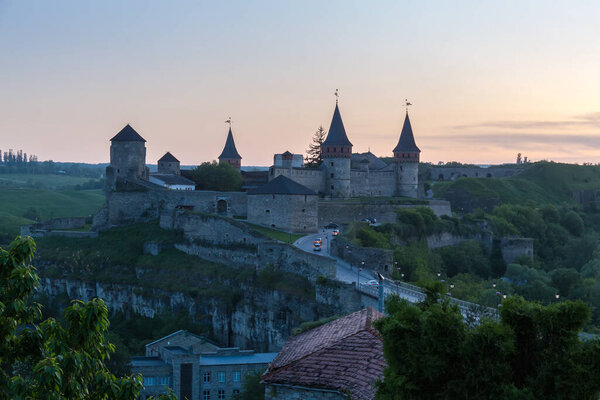 Ancient fortress of the 14-18th centuries with Castle Bridge on a foreground in Kamianets-Podilskyi city, Ukraine. General view from the Old Town side in spring evening