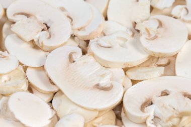 Taze pişmemiş mantarlar ince dilimler halinde doğranmış, seçici odak noktasında yakın plan.