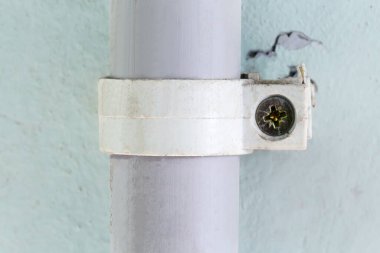 Plastik boru, iletişim kablolarını çekmek için plastik boru klempi ile beton bir duvara sabitlenmiş ve kapalı kapılar vidalanmıştır.