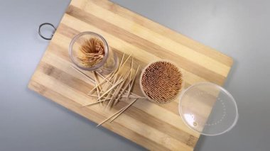 Kesme tahtasındaki plastik kaplarda ahşap kürdanlar, üst manzara