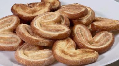 Gri arka plandaki tabakta düz poğaça kelebeği kurabiyeleri