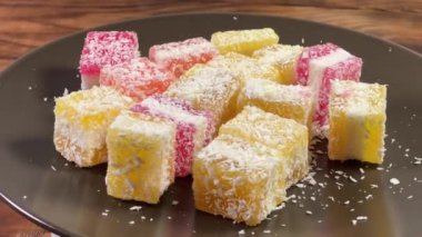 Çok renkli katmanlı meyveli jöle şekerleri. Üzerinde de hindistan cevizi serpiştirilmiş.