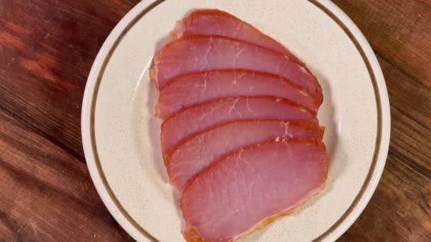 ロマンチックなテーブルのソーサーにスライスした乾燥した豚肉 — ストック動画
