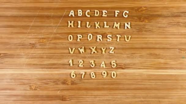 アルファベット文字のパスタとカッティングボード上の数字の形状 — ストック動画