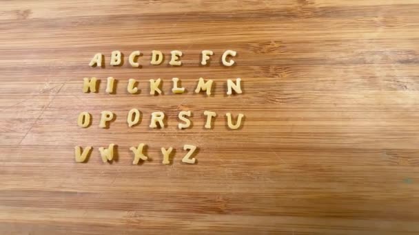 Pasta Buchstabenform Auf Holzschneidebrett — Stockvideo