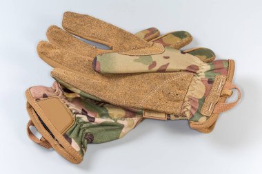 Pair of the beige tactical military gloves made with textile and synthetic leathern on a gray background clipart