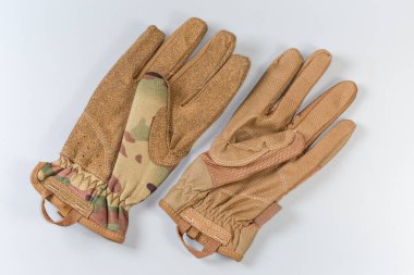 Two different tactical military gloves made with textile and synthetic leathern protective color on a gray background clipart