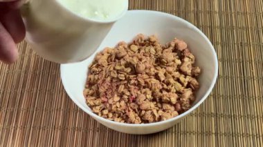 Kurutulmuş meyveli müsli ile kâseye süt dök.
