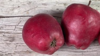 Kırık ahşap yüzeyde kırmızı elmalar, üst manzara.