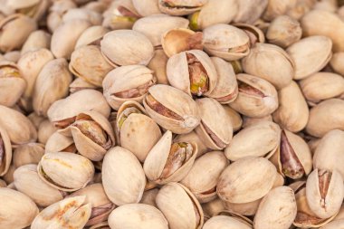 Kısmen açık kabuklu kavrulmuş şam fıstığının arka planı, seçici odak noktasında üst görüntü.