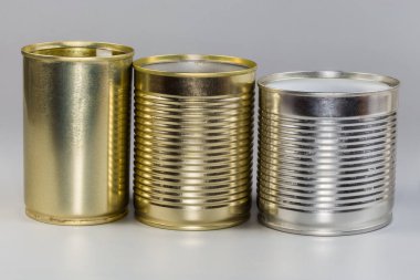 Different open empty tin cans from under a canned food, with various white and yellow covering on a gray background, side view clipart