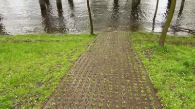 Sel sırasında nehir suyundaki ağaçlar ön planda yaya yolu ile