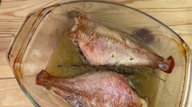 Kırsal masadaki eski cam fırında pişmiş kırmızı balıklar.
