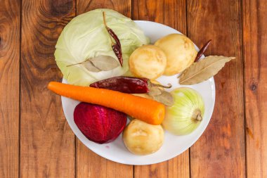 Kırmızı pancar çorbası hazırlamak için kırmızı pancar çorbası malzemesi olarak kabuğu soyulmuş taze sebzeler, beyaz lahana ve kurutulmuş baharatlar.