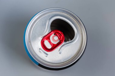 Gri zemin üzerinde gümüş kaplama ve kırmızı çekme sekmesi olan boş alüminyum içecek kutusu kullanılıyor, üst görünüm