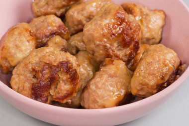 Kızarmış ve sonra haşlanmış et köfteleri, ayrıca pembe kasede dairesel şekilli doğranmış pirzola olarak da bilinir, yakın plan.