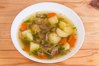 Yeni hazırlanmış sıcak ev yapımı tavuk çorbası. Kırsal masadaki beyaz kasede az pişmiş vermicelli var.