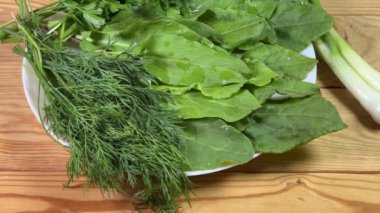 Kır kuşu yaprakları, yeşil soğan, maydanoz ve dereotu köy masasında.