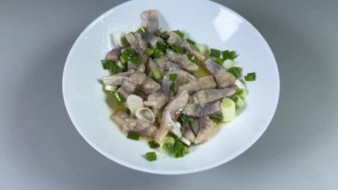 Dilimlenmiş ringa balığı ve yeşil soğan.